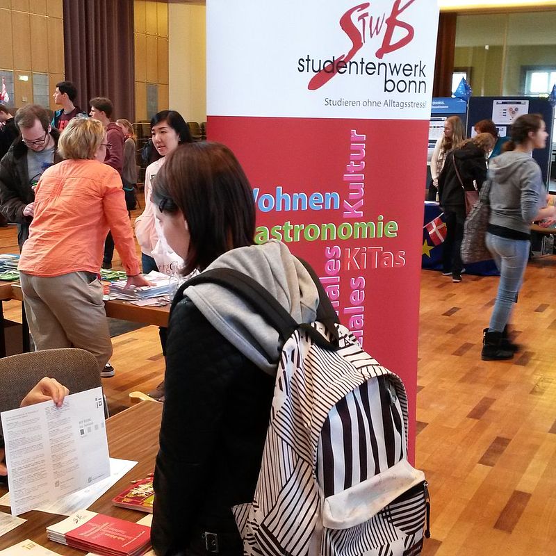 Besucherinnen und Besucher im Speisesaal an verschiedenen Aktionsständen