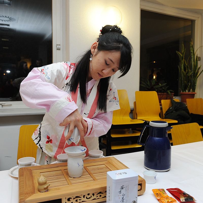 Studentin in traditioneller Kleidung macht Teezeremonie auf dem Chinesischen Neujahrsfest