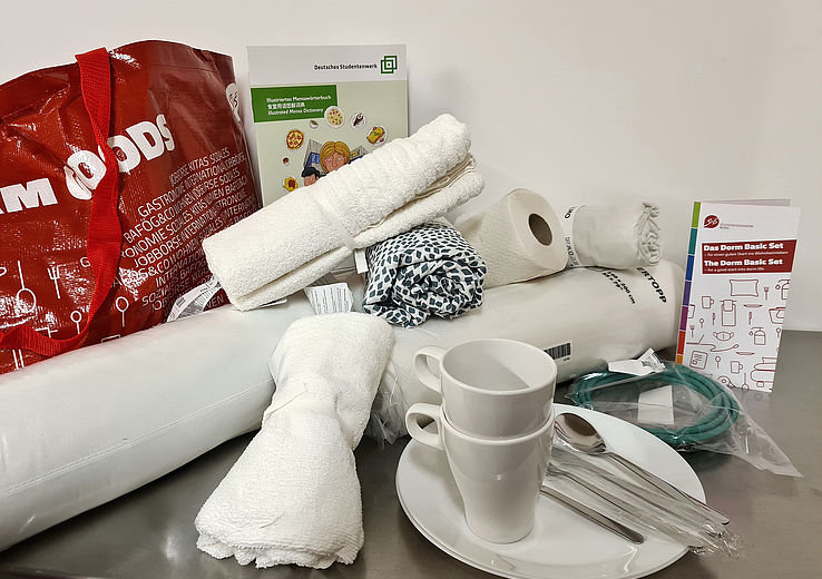 The contents of a Dorm Basic set, i.e. towels, cups, cutlery, plates, bedding, etc