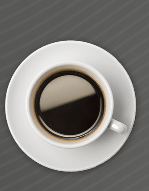 Zwei Kaffeetassen von oben fotografiert, die zwei Augen darstellen sollen mit einem gezeichneten Strich darunter, der einen lächelnden Mund darstellen soll.