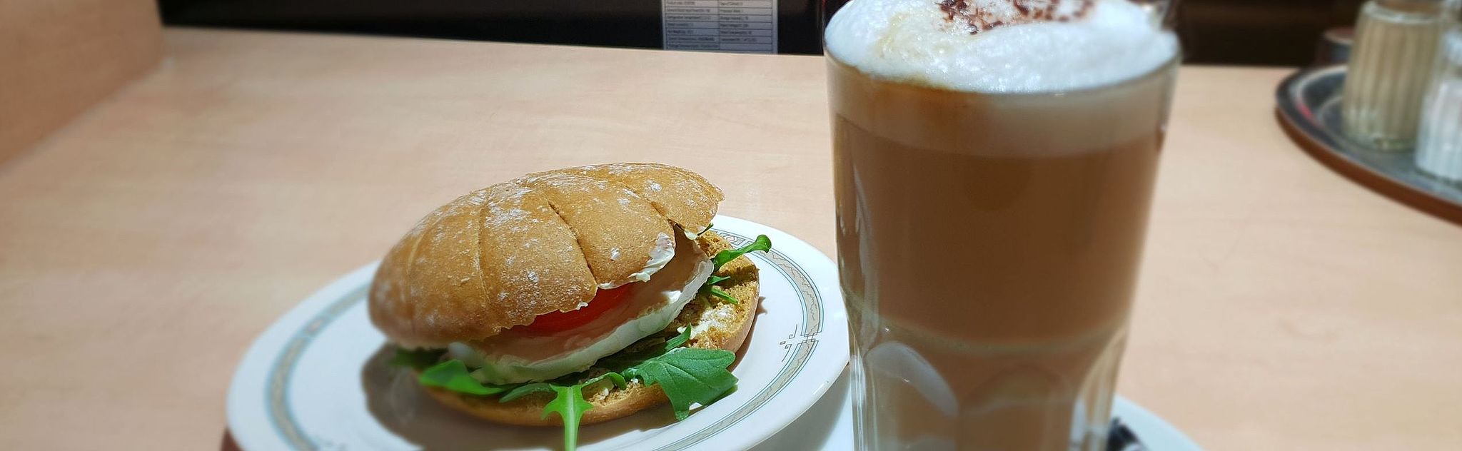 Seeded sandwich roll with a large latte macchiato
