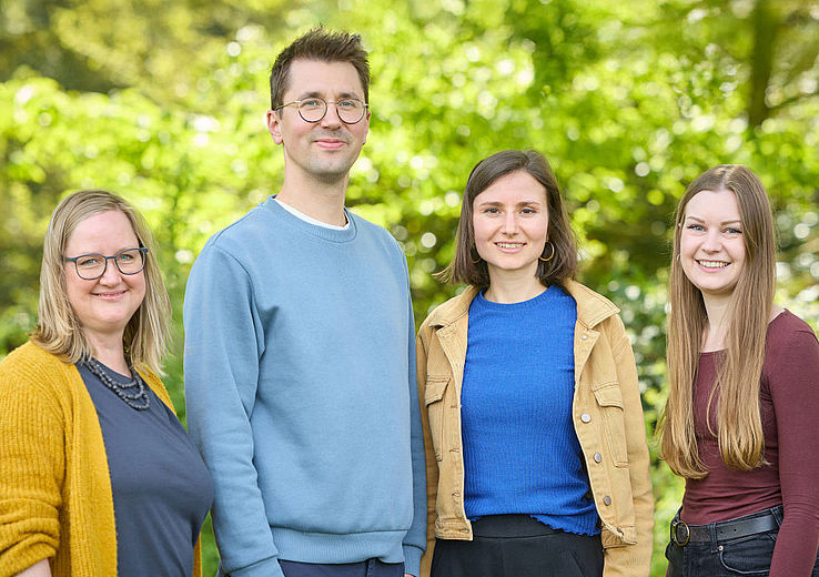 The team from the Psychological Counselling Centre are standing in front of some trees in the Botanical Gardens, smiling warmly at the camera.